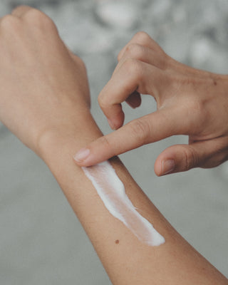 Ein Arm wird sanft mit der 5% Urea Bodylotion eingecremt.