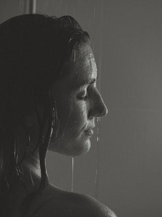 Nahaufname des Gesichts einer Frau unter der Dusche