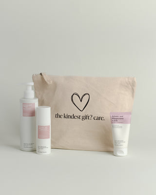Hellbrauner Baumwoll-Kosmetikbeutel mit einem schwarz umrandeten Herz und Aufschrift "the kindest gift? care." Davor stehen 3 Intimpflegeprodukte von Phametra Cosmetics.