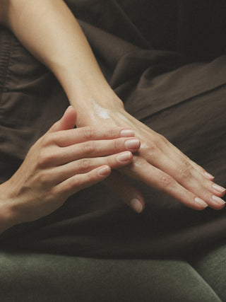 Nahaufnahme von Händen die eingecremt werden.