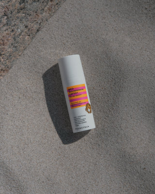 MED Sonnencreme Kids liegt auf Sand. 
