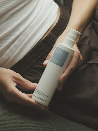 Nahaufnahme einer Urea Bodylotion, die in beiden Händen gehalten wird.