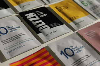 Bunte Sachets mit Hautpflege-Produkte von Phametra liegen geordnet in mehreren Reihen auf hellem Hintergrund