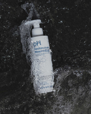 Der weiße Pumpspender der Phametra pH hautneutralen Waschlotion wird von Wasser umspült